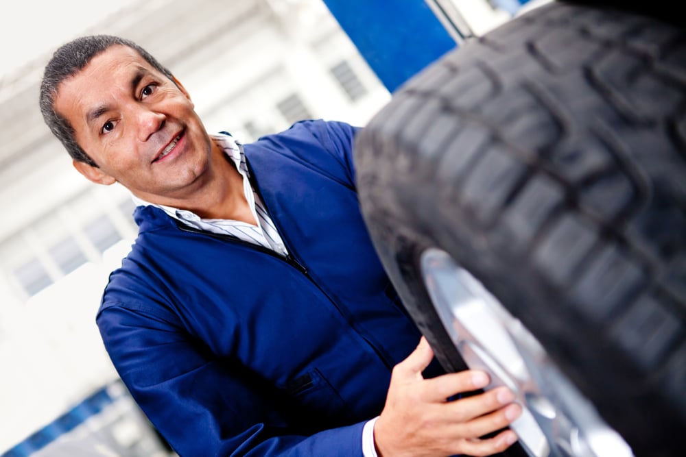 Mechanic changing car wheel at a repair shop